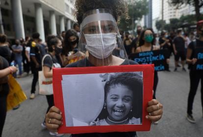 Mulher empunha foto de Ágatha, morta aos 8 anos durante uma ação policial no Rio de Janeiro em 2019.