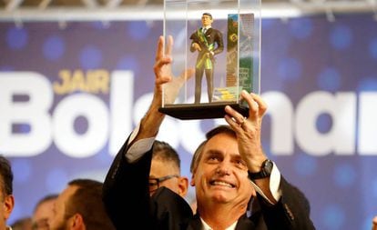Jair Bolsonaro segura um boneco que o representa em Curitiba no dia 29 de março.