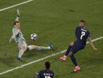El delantero francés del PSG, Kylian Mbappe, dispara a puerta ante el portero alemán del Bayern Munich, Manuel Neuer.