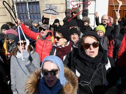 Mulheres portam cabides (faz anos usavam-se em abortos clandestinos) em uma manifestação em Varsóvia em março.