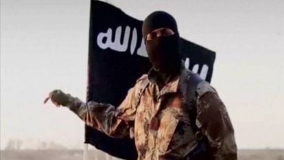 Jihadista com bandeira do Estado Islâmico (EI) ao fundo.