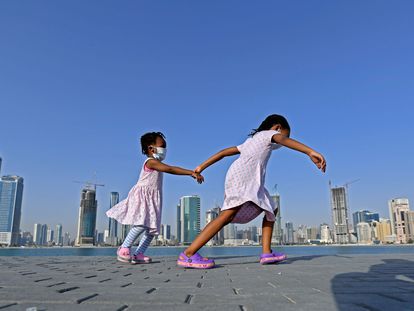 Meninas caminham à beira-mar no distrito de al-Mamzar, em Dubai, em 14 de maio, após flexibilização das medidas de bloqueio da pandemia.