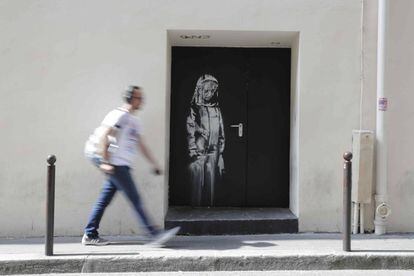 Um homem passa, em julho, diante da saída de emergência do Bataclan com a obra de Banksy.