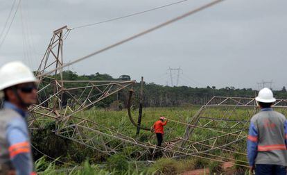 Técnicos ao lado de torre de transmissão de energia destruída no Ceará.