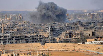 Uma coluna de fumaça se eleva sobre a cidade de Deir Ezzor durante uma operação do regime contra posições do EI.