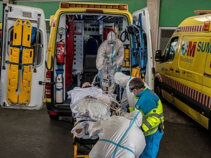 Profissionais sanitários transferem um paciente em Madri, em 23 de outubro.