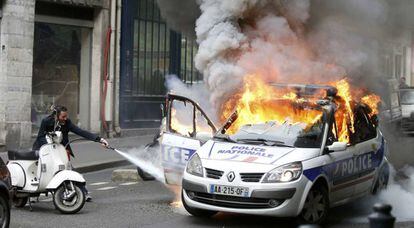 Carro da polícia em chamas por manifestantes em Paris.