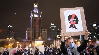 Uma mulher com um cartaz da organização feminista que lidera os protestos contra o Governo da Polônia na sexta-feira em uma enorme manifestação em Varsóvia.