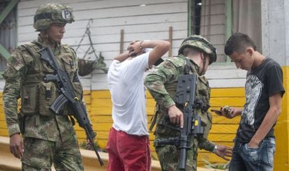 Militares revistam jovens na periferia de Medelín.