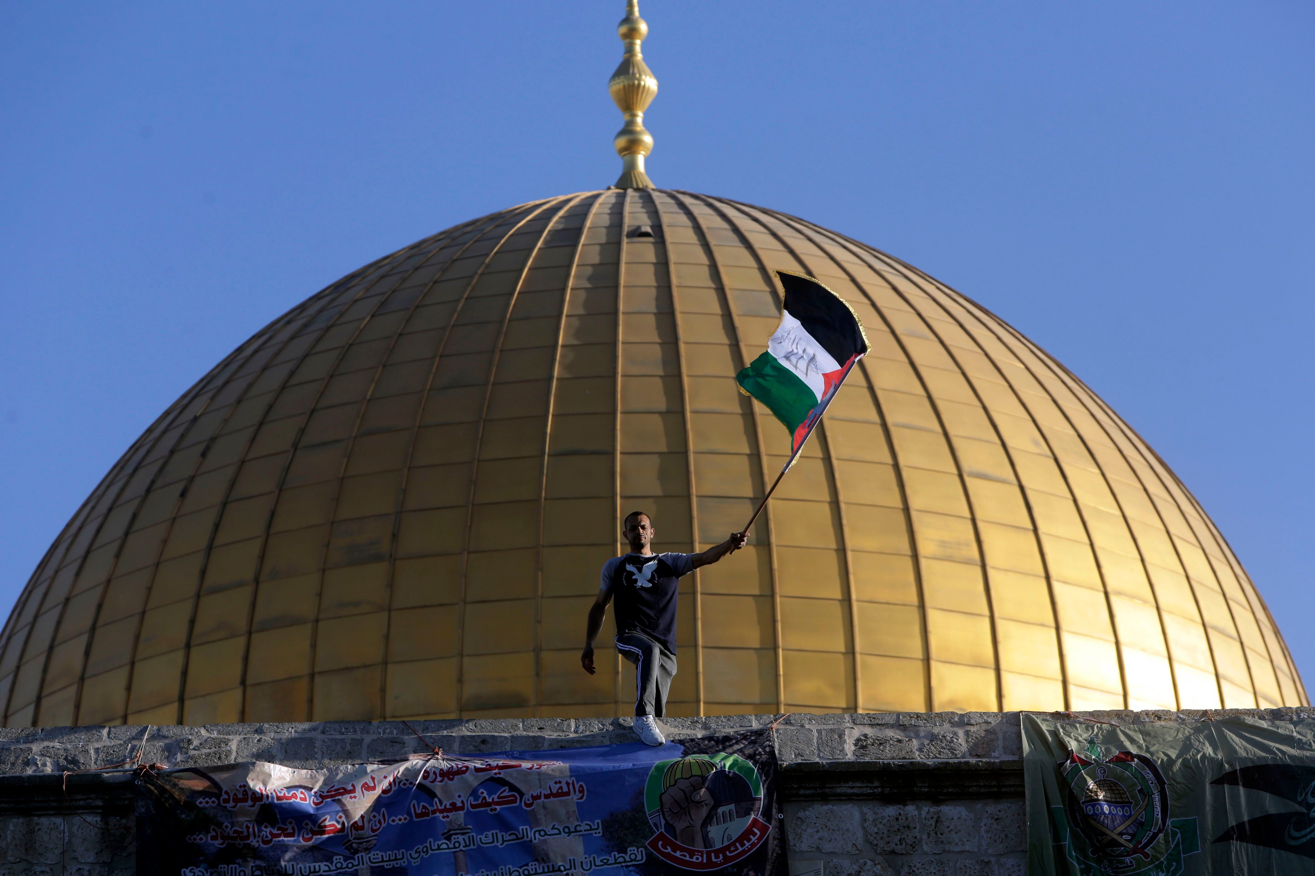 Homem tremula a bandeira palestina em Al Aqsa, Jerusalém, durante as celebrações do Eid al-Fitr, nesta quinta-feira. 
