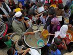 Aldeões afegãos recebem comida para romper o jejum durante o mês sagrado do Ramadã em Cabul, em 3 de julho de 2014.