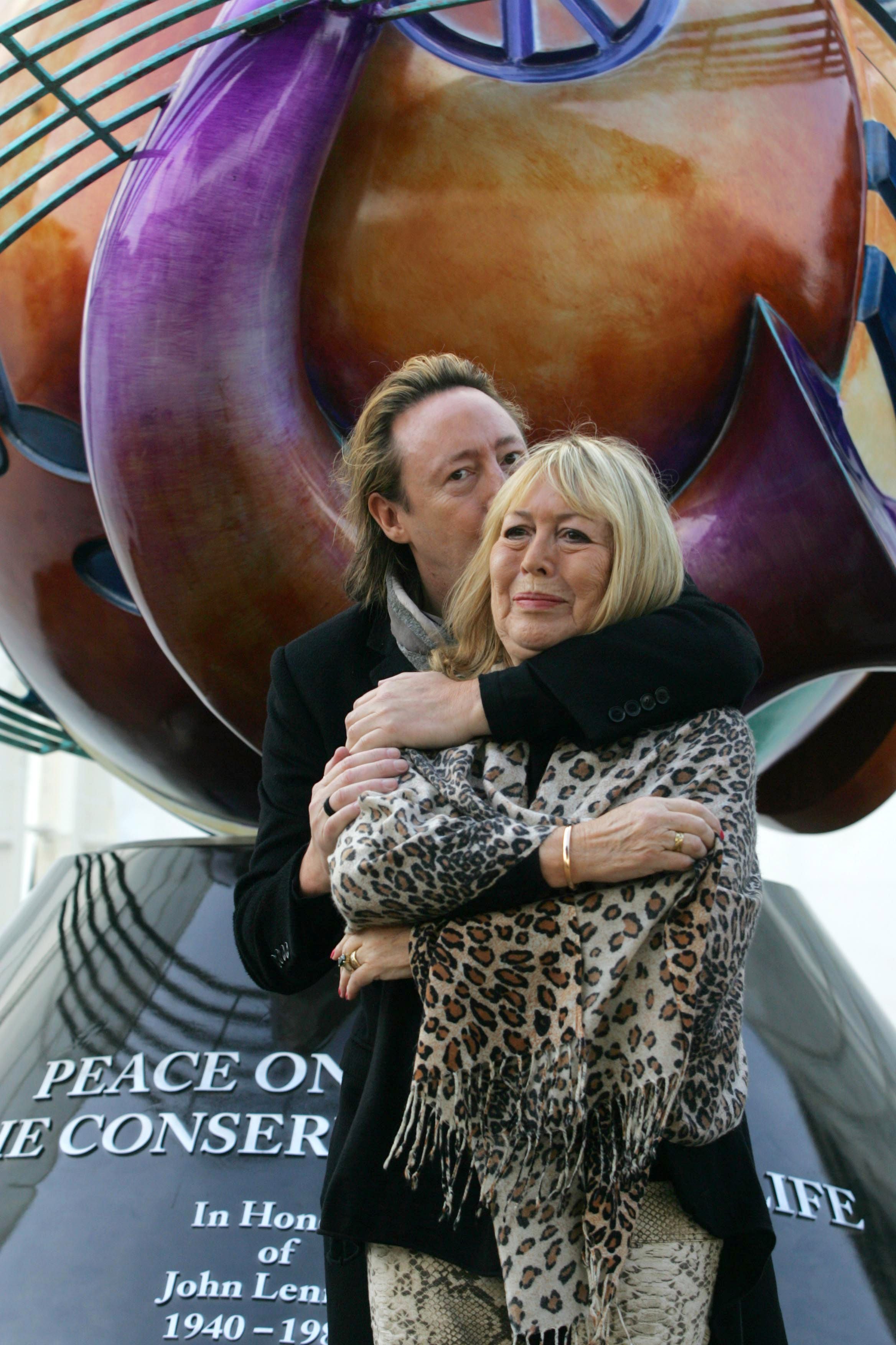 Julian Lennon abraça sua mãe Cynthia em Liverpool durante a inauguração de um monumento à paz para celebrar o aniversário de 70 anos de John Lennon, em outubro de 2010.