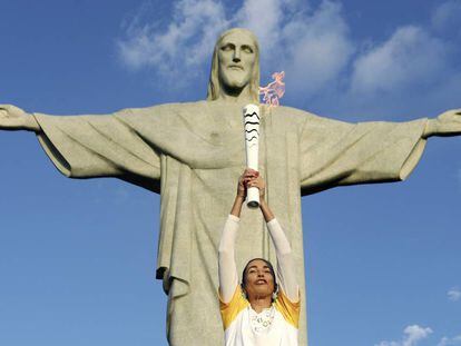 A campeã olímpica de vôlei de praia, Isabel, leva a tocha ao Cristo Redentor.
