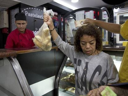 Clientes compram pão subsidiado em uma confeitaria de Caracas