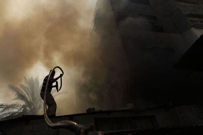 Um homem apaga as chamas de um incêndio provocado por um forte bombardeio em Gaza, em 30 de julho de 2014.