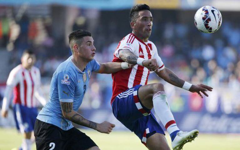 José Giménez, do Uruguai, marca o atacante paraguaio Lucas Barrios.