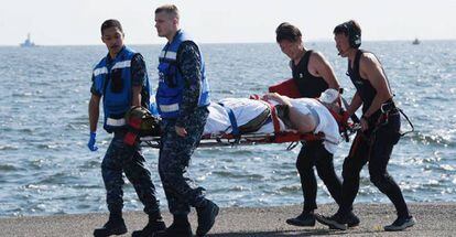 Militares americanos e japoneses evacuam um dos marinheiros feridos