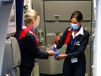 Flight attendants wearing face masks sanitise their hands inside a plane at the Zaventem International Airport, as Belgium eases restrictions aimed to contain the spread of the coronavirus disease (COVID-19) outbreak, near Brussels, Belgium June 15, 2020. REUTERS/Francois Lenoir