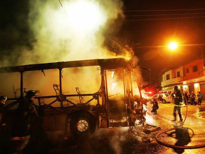 Bombeiros apagam chamas de &ocirc;nibus incendiado por integrantes do PCC na Vila Madalena, zona oeste de S&atilde;o Paulo, em maio de 2006. V&aacute;rios &ocirc;nibus foram incendiados naquela semana. 