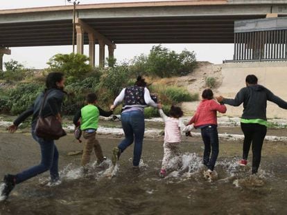 Um grupo de imigrantes cruza o rio entre Cidade Juárez (México) e EL Paso (EUA), nesta segunda-feira