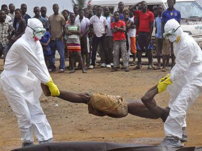 Em Monróvia, na Libéria, as equipes de saúde pública removem o corpo de um homem suspeito de ter contraído o ebola.