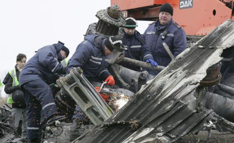 Trabalhadores retiram restos da fuselagem do avião em Grabovo.