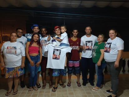 Kelvin, de boné azul, Alex, de boné vermelho, e Eryk, de camiseta cor de vinho, celebram com os pais no dia em que foram libertados em São Paulo.