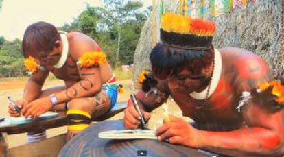 Homens fazem ilustrações indígenas nos chinelos, em Goiás.
