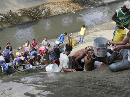 Venezuelanos coletam água no Rio Guaire, em Caracas.