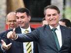 Brazilian President Jair Bolsonaro (R) and his son, senator Flavio Bolsonaro, gesture during the launch of his new party, the Alliance for Brazil, at a hotel in Brasilia on November 20, 2019. - Bolsonaro left the Social Liberal Party after a disagreement with the party president Luciano Bivar. (Photo by EVARISTO SA / AFP)
