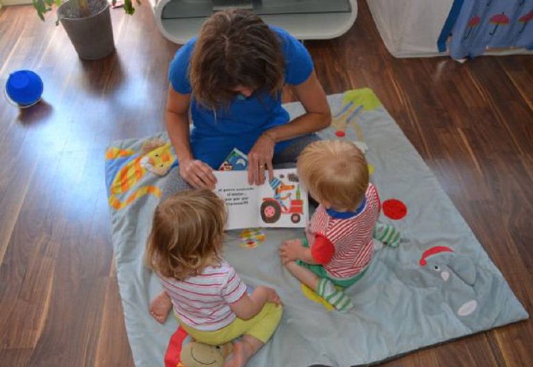 Diana Perazzini, babá, lê uma história para Nina e Lucas antes de dormirem.