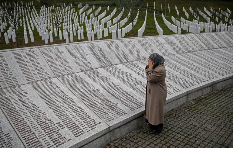 Uma mulher reza diante da placa com os nomes das vítimas de Srebrenica em Potocari (Bósnia), em 2016.