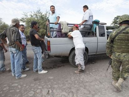 Membros do Exército mexicano inspecionam veículos na estrada que liga Apatzingán a Aguililla (Michoacán) dia 24 de janeiro.