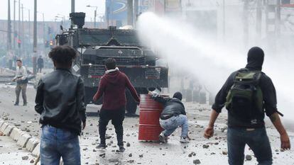 A polícia antidistúrbios em frente a um grupo de manifestantes nesta sexta-feira, em Bogotá.