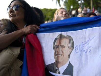 Uma mulher segura uma bandeira com a imagem de Vázquez.