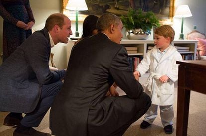 O príncipe George, de roupão, cumprimenta o presidente Obama.
