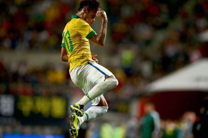 Neymar pula de alegria ao comemorar um gol de falta em amistoso com o Brasil.