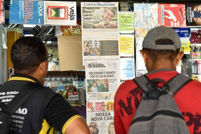 Homens leem as manchetes em banca de jornal de Brasília.