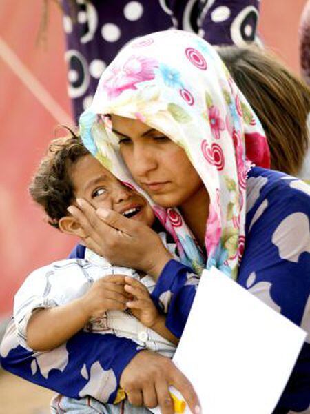 Uma refugiada síria consola seu filho na fronteira com a Turquia.