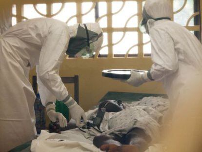 O doutor Brantly (esquerda) trata um paciente de ebola.