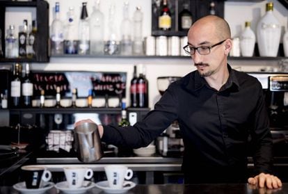 Um garçom prepara três cafés em um bar de Madri.