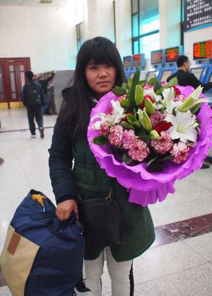 Gong Zhuling, auxiliar administrativa de 28 anos, espera que o buquê de flores com que vai presentear sua mãe aguente as oito horas de viagem.