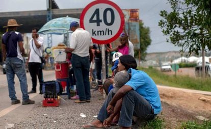 Refugiados venezuelanos formam fila em ponto de imigração brasileiro.