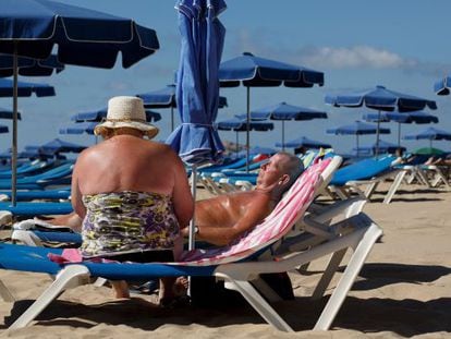 Um casal toma sol na praia de Benidorm.