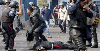 Policial fica caído após ser atropelado durante os protestos.