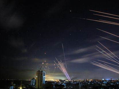 O sistema israelense de defesa antimísseis Cúpula de Ferro (à esquerda) intercepta foguetes disparados pelo Hamas, no domingo passado.