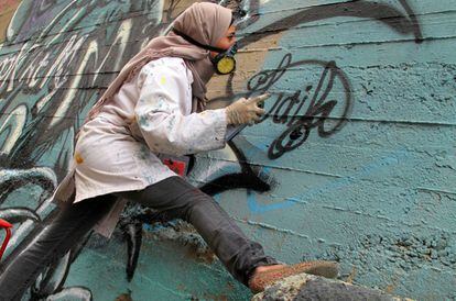 A grafiteira palestina Laila Ayawi durante participação na Jordânia, em 2014.