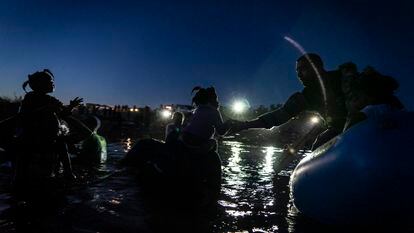Um agente fronteiriço dos Estados Unidos ajuda uma menina a subir numa lancha no rio Grande, nesta quinta-feira.