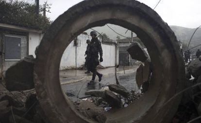 Soldados passam por barricada durante opera&ccedil;&atilde;o surpresa na favela da Coreia, no Rio de Janeiro.