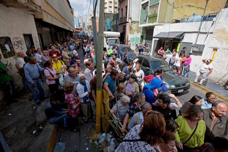 População faz fila em um supermercado para comprar papel higiênico com preço regulado disponibilizado nesta sexta-feira pelo Governo venezuelano em Caracas.